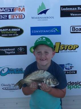 Future fisherman: Warrnambool's Angus McKenna was undeterred by the weather when he was showing off his catch of bream in the Under 10s 'Small Fry' category of the annual fishing competition on Wednesday night.