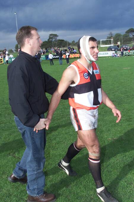 Game over: A battered Jason Mifsud with winning Camperdown coach Ken Hinkley after the Saints leader played out the 2000 grand final despite suffering a head knock.