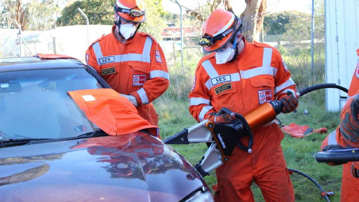 Heywood member Adrian Hodgens (right) uses the jaws of life while Port Fairy's Sean Mulready watches on. Picture: Port Fairy Ses