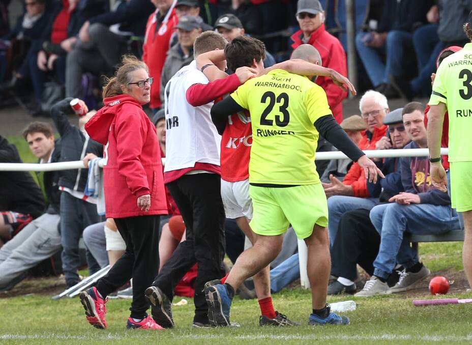 SAFE HANDS: A South Warrnambool player is taken off the ground by trainers. 