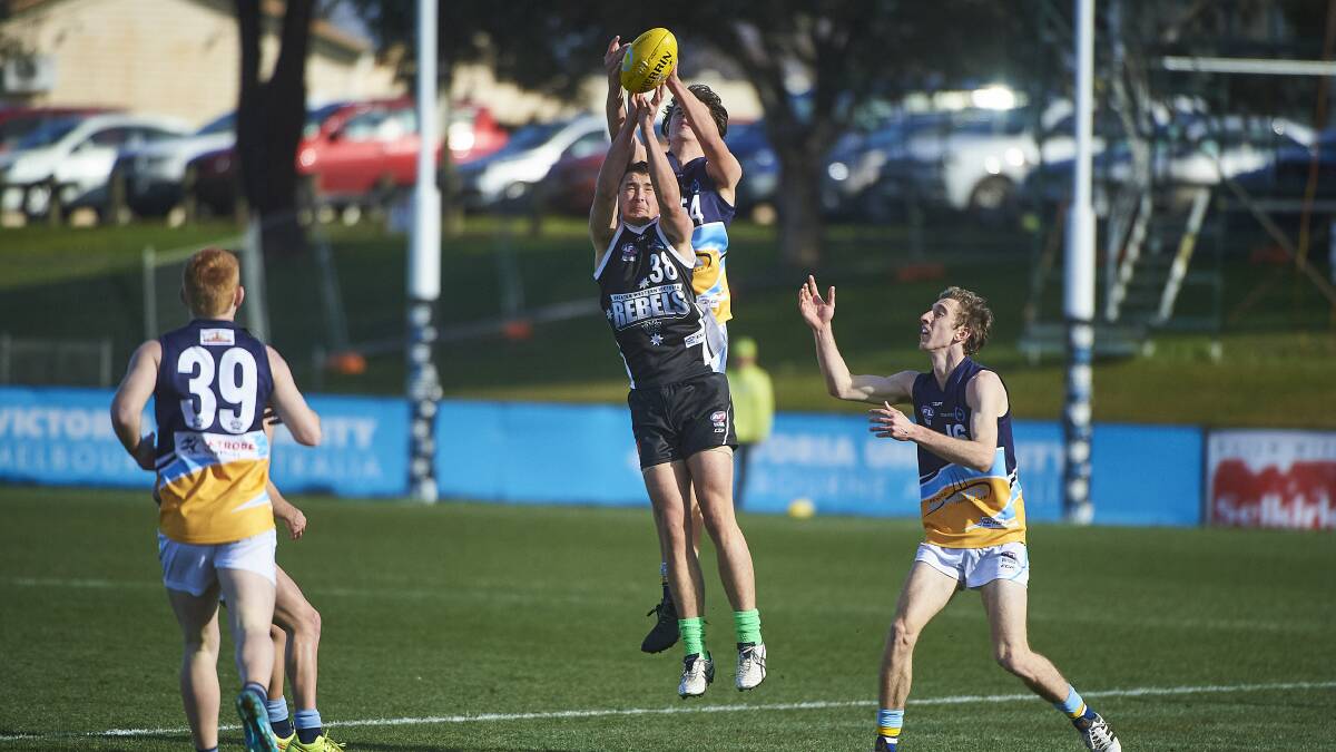UP HIGH: Izaac Ewing (front) playing for the Rebels in 2018. Picture: Luka Kauzlaric/Ballarat Courier