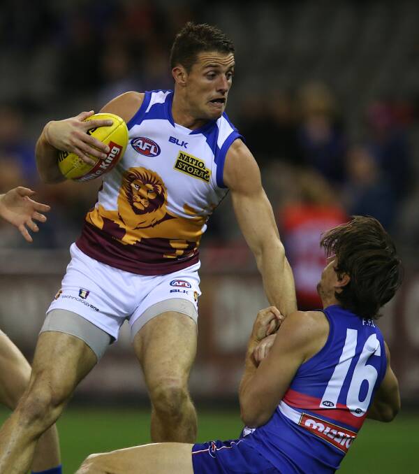 TOO STRONG: Matt Maguire pushes away a tackle attempt from Ryan Griffen.