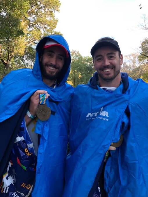 JOB DONE: Twin brothers Adam and Paul McCosh pose for a photo at the finish line of the New York Marathon. The pair ran with Steve Watty in the popular event.