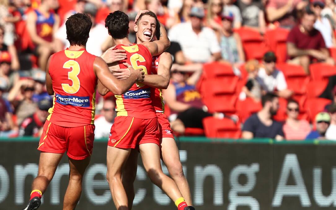 FIRST TASTE: Josh Corbett celebrates his first goal with Jack Bowes and Alex Sexton. Picture: AFL Photos