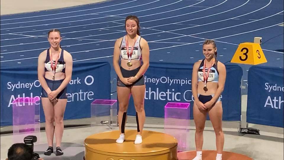 SILVER: Warrnambool's Grace Kelly (left) stands on the podium to collect her silver medal from the 100 metres. 