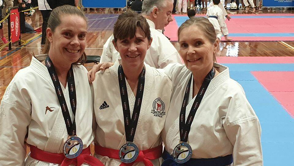 STRONG FORM: Jill Cole (middle) poses for a photo after claiming a silver medal.