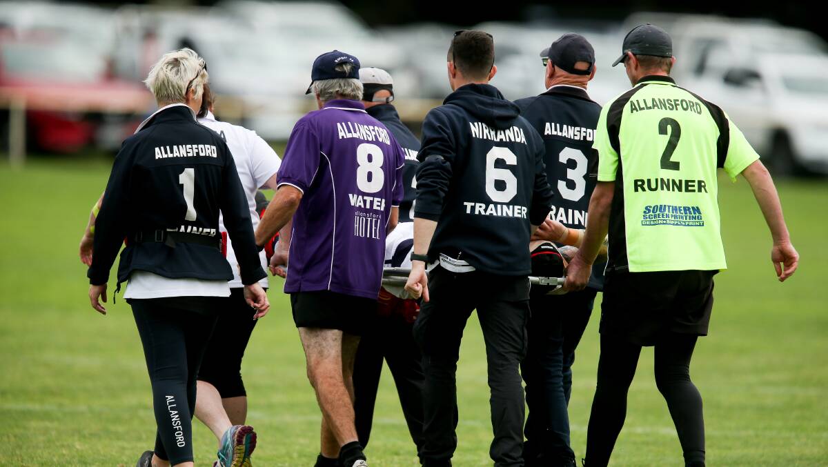 SAFE HANDS: Trainers carry Tyler Mungean off the field. Picture: Chris Doheny