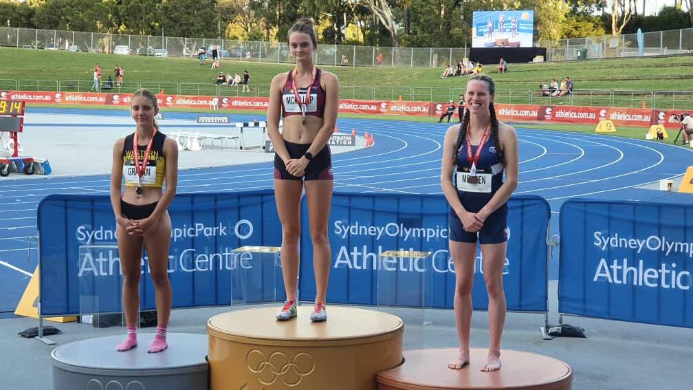 PROUD MOMENT: Emily Morden (right) stands on the podium for the under 20 3000-metre steeplechase. 