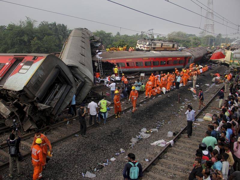 Rescuers are searching the mangled wrecks of two passenger trains that collided in India. (AP PHOTO)