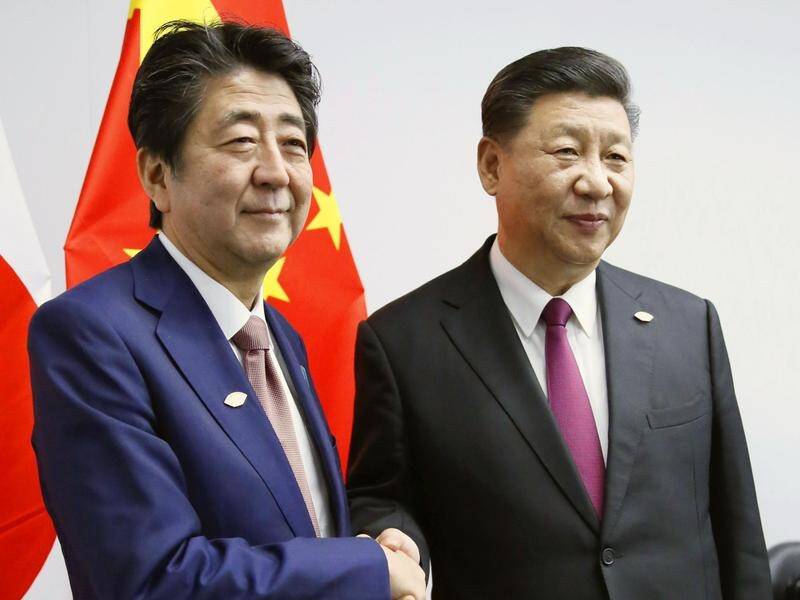 Chinese President Xi Jinping (R) will visit Japan in June.