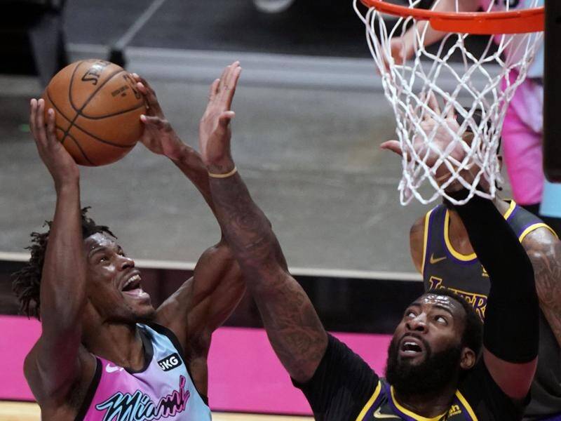 Miami forward Jimmy Butler drives to the basket as Lakers centre Andre Drummond defends in vain.