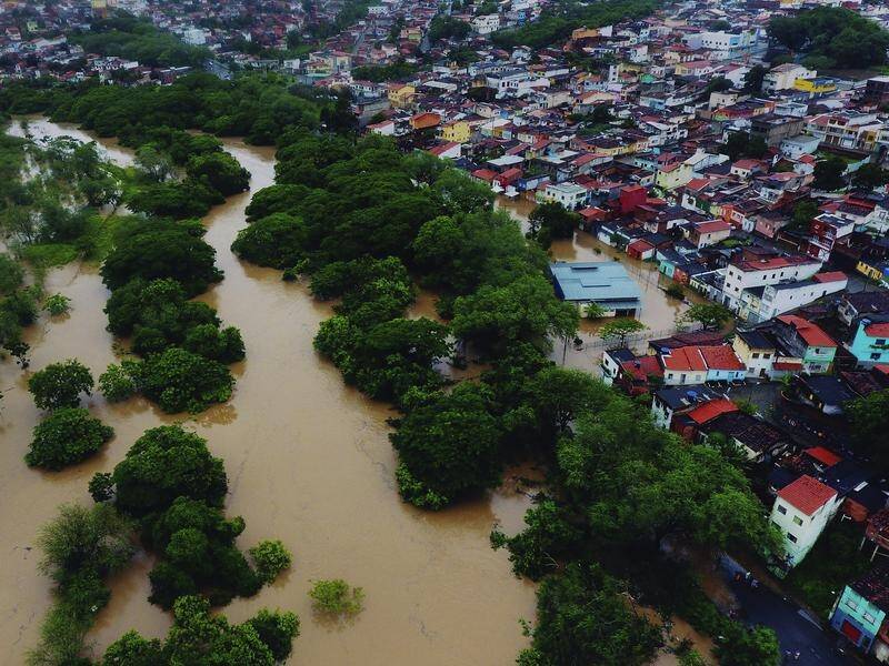 Floods in northeast Brazil have killed at least 20 people and displaced tens of thousands.