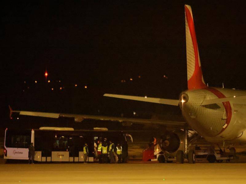Twelve passengers who fled a plane at Mallorca airport are arrested, police search for 12 more.