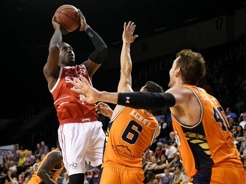 Cedric Jackson (C) has helped the Illawarra Hawks beat the Taipans to go equal fifth in the NBL.