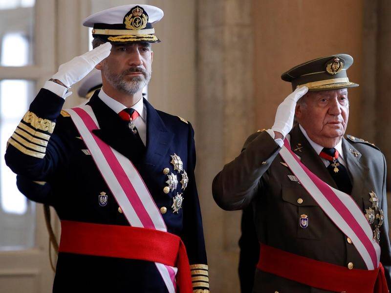 Spain's former monarch Juan Carlos (right) has told his son King Felipe that he is leaving Spain.