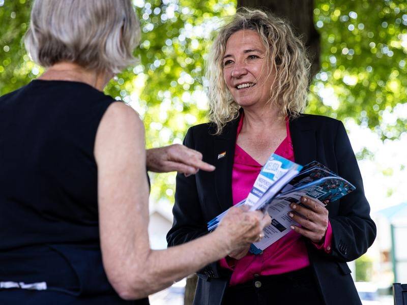 Teal candidate Melissa Lowe hands out how-to-vote cards at a pre-polling station at Camberwell. (Diego Fedele/AAP PHOTOS)