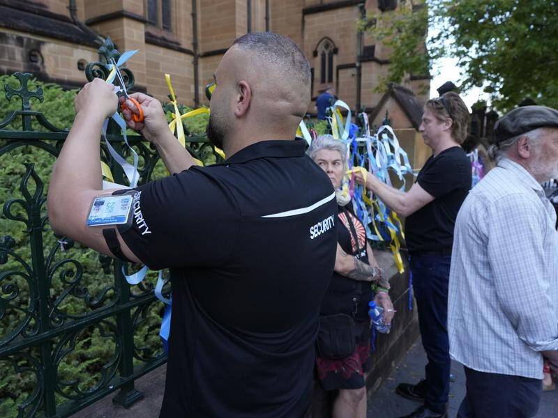 Security guards have cut off some of the ribbons attached to St Mary's Cathedral's fence. (AP PHOTO)