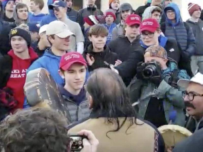 Nicholas Sandmann, centre in red MAGA hat, faces off with Nathan Phillips in January.