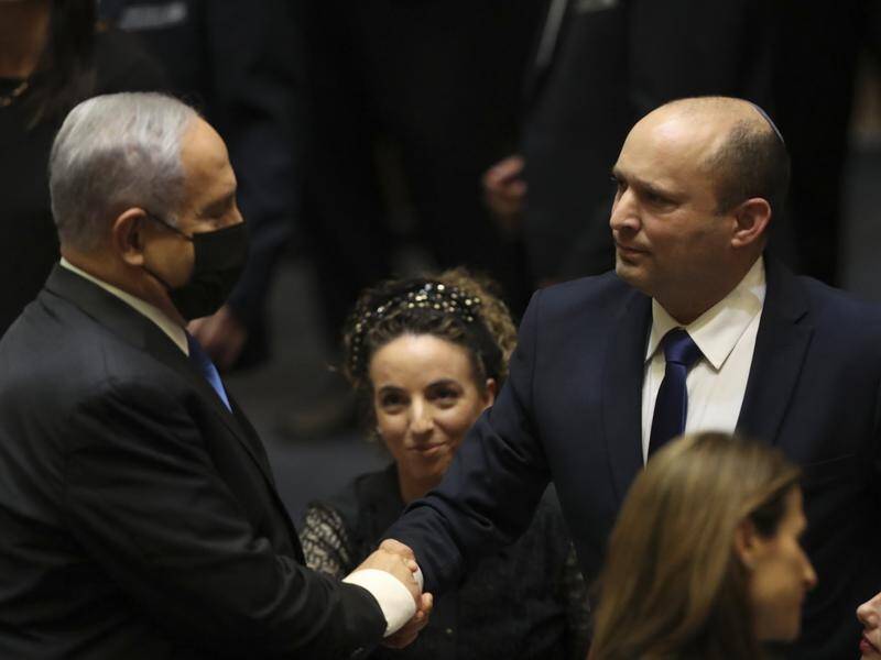 Israel's new prime minister Naftali Bennett (R) has been sworn in, replacing Benjamin Netanyahu.