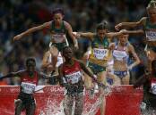 Big jump: LaCaze, at right, in the final of the 3000m steeplechase at the Glasgow Games.  Photo: AFP/Adrian Dennis