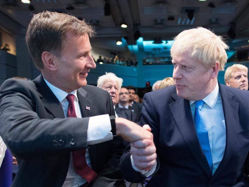 Jeremy Hunt and Boris Johnson react as Johnson is announced as the new Conservative party leader.