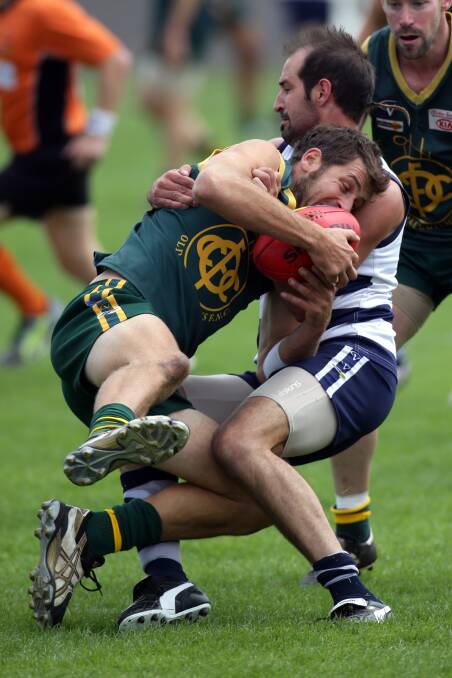 Old Collegians’ Daryl Beechey tries to escape the clutches of Allansford’s Ben Lenehan.