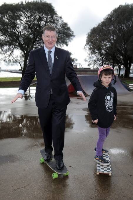 Premier Denis Napthine tries his hand at skateboarding, with the help of Kostya Vallance, 8, of Portland. Picture: ROB GUNSTONE