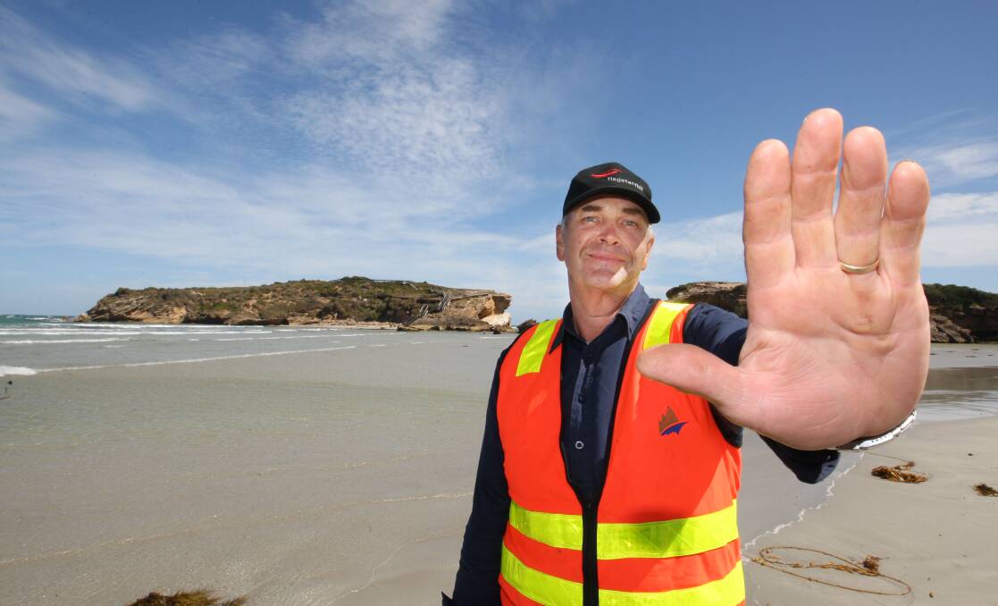 Warrnambool City Council dog handler Phil Root gets the message across at Stingray Bay, where a build-up of sand has left the Middle Island penguin population vulnerable to foxes and other intruders. 