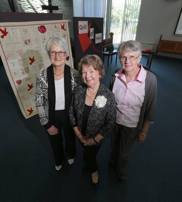 The Quilt of Hope, created by sexual abuse survivors, their families and supporters, was displayed in the St Joseph’s church foyer by quilt makers Carmel Moloney (left), Beryl Andersen and Lyn Snibson. Picture: VICKY HUGHSON