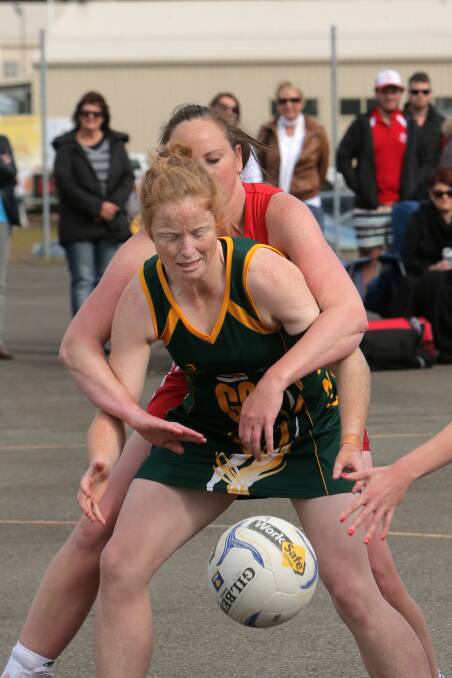 Old Collegians goaler Steph Townsend is locked up by Dennington’s Sue Fleming.