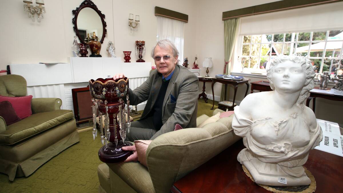 Auctioneer Brian O’Halloran with an 1860s ruby glass lustre vase, brought from England by the Swinton family.