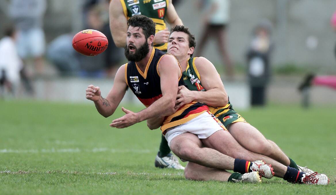 WDFNL’s Leatham Robe gets a handball away from the tackle of Colac and District’s Luke Weel in last Saturday’s interleague clash.