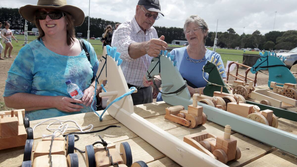 Johanne Drake, of Allansford, Neil Boxhall, from the Simpson Mens Shed group, and Marion Coots, of Cooriemungle, look at the toys made by the Mens Shed being sold at the Heytsbury. 