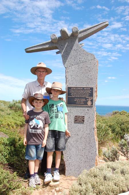 Craig Baulderstone and his sons at the memorial for the aircrew lost in a crash off the coast of Lady Julia Percy Island. 