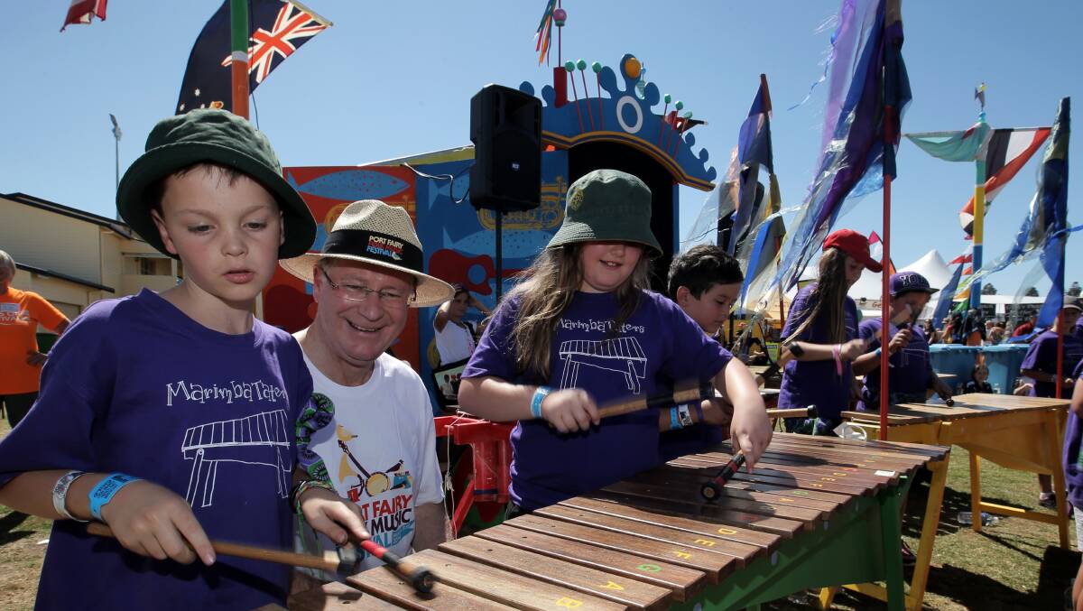 Caleb Venn (left) and Caitlyn Essler from Tate St Primary School, Geelong teach Premier Denis Napthine to play the Marimba.