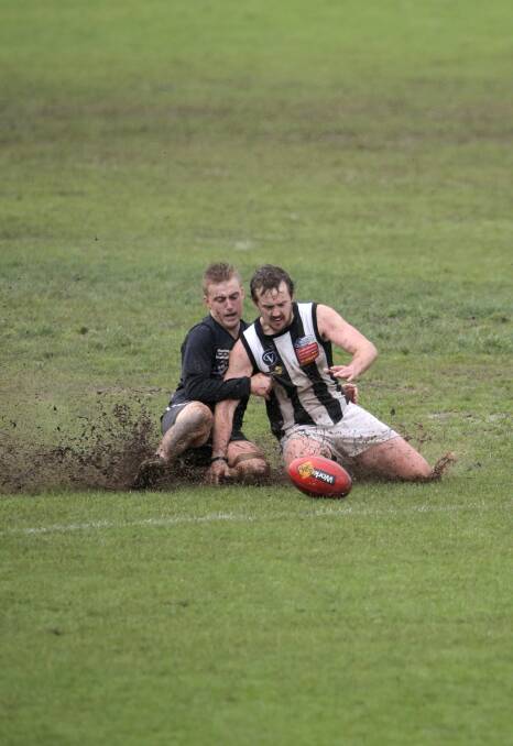 Slip slidin’ away: Warrnambool’s Kurt Lenehan (left) and Camperdown’s Luke Clarke battle the waterlogged Reid Oval, as well as each other, in a tough day for football on Saturday. 