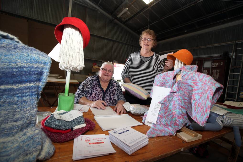 Warrnambool show arts and crafts judge Jill Mellor (right) casts an expert eye over entries yesterday, assisted by steward Ann Kertland. 141022DW10 Picture: DAMIAN WHITE