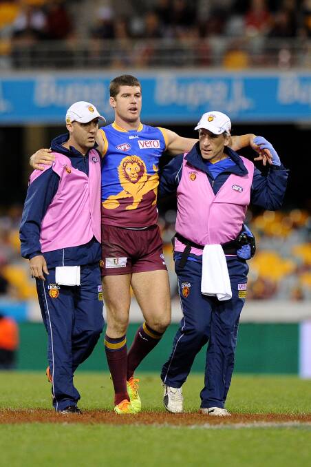 Jonathan Brown is assisted from the field at The Gabba on Saturday night. Picture: GETTY IMAGES