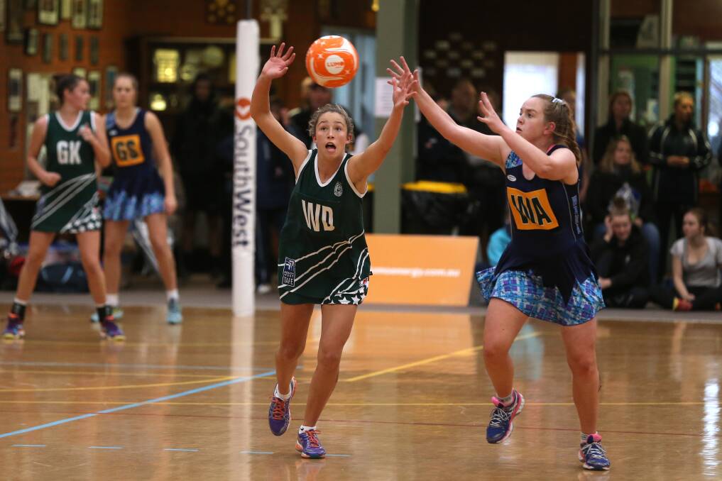 Hampden wing defence Kira Bussell (left) and Western Border opponent Casey Horrigan lunge for possession in the Netball Victoria Association Championships western zone 17 and under final. 150531DW57 Pictures: DAMIAN WHITE