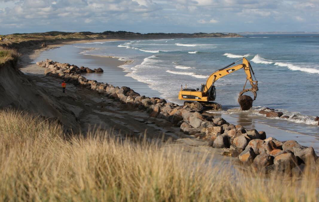Work continues to extend a rock wall in front of eroding dunes that are home to an old rubbish tip on Port Fairy’s East beach. 150519AS20 Picture: AARON SAWALL