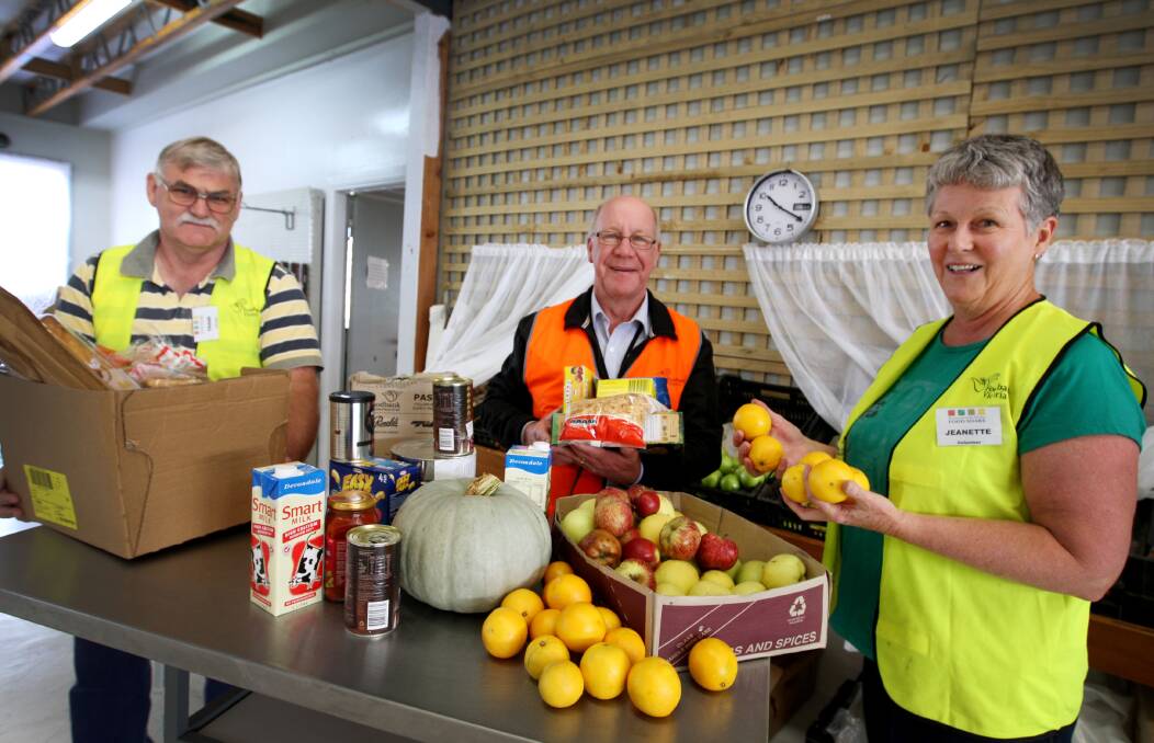 Warrnambool and District Food Share volunteer Frank Breed (left), executive officer Dedy Friebe and volunteer Jeanette Brennan help prepare food parcels for delivery to needy families. 