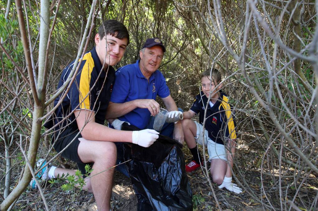 Clontarf Academy students (left) Latrell Campbell, 15, and John Williams, 14, help Rotary’s Glenn Rundell bag rubbish.11217LP65 Picture: LEANNE PICKETT
