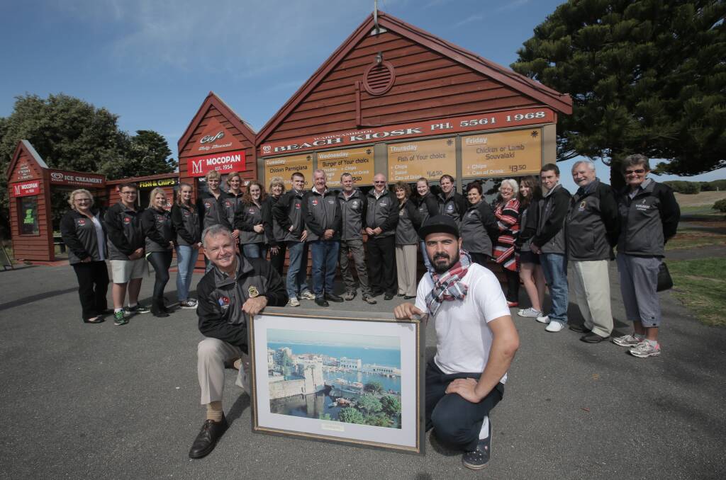 Warrnambool RSL committee member Doug Heazlewood (front left) holds a framed photograph of Gallipoli with Engin Torun, the son-in-law of former Beach Kiosk owner Sam Meric, who the tour group of secondary school students, parents and teachers will meet on their trip to Turkey. 