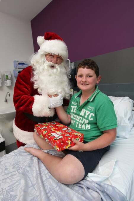 Patient Gus Egan, 9, from Coleraine, thanks Santa for his unexpected gift.  141216AS31 Picture: AARON SAWALL