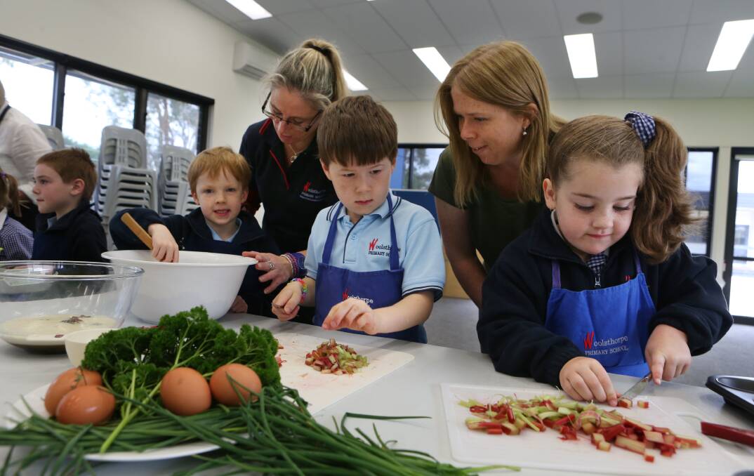 Hugo Jarrold, 5, stirs a bowl with help from Suzi Ireland, while Lachlan Taylor, 6, and Marli McRae, 5, get chopping under the watch of parent Elissa Taylor.
140522LP01 Picture: LEANNE PICKETT