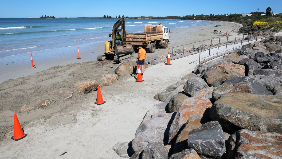 Workers reinforce a pathway and rock wall along a section of East Beach, Port Fairy, this week. 140922RG23 Picture: ROB GUNSTONE