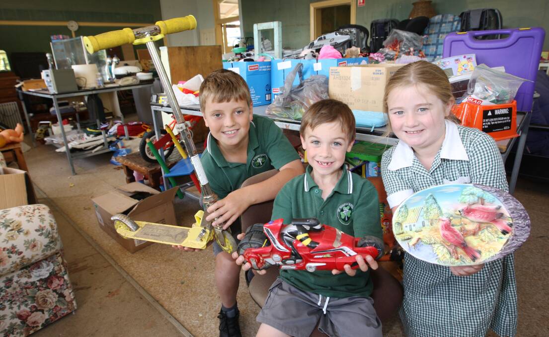 Something for everyone: Jake McCosh, 10 (left), Thomas Paturzo, 6, and April King, 7, holding items for sale in the bric-a-brac room at this weekend’s St Patrick’s Primary School fete in Koroit.  