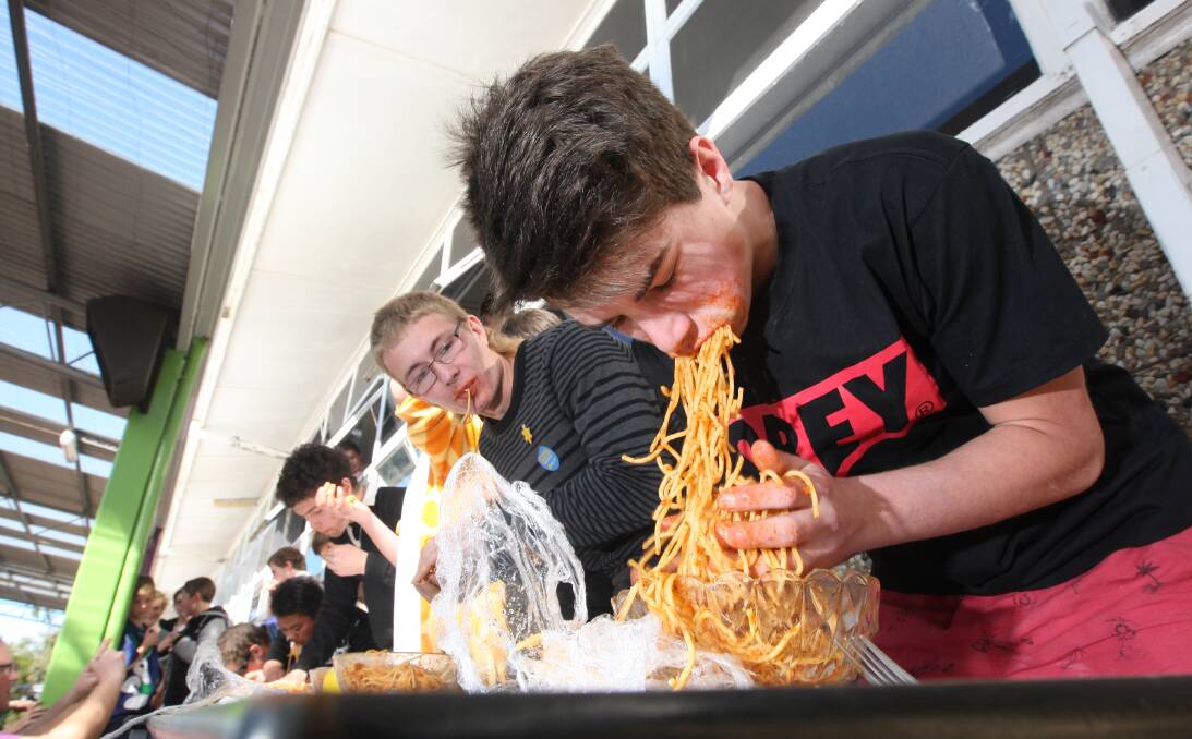 Liam Collins, 15 (right) and Corey Johnstone, 16, put the cutlery — and manners — to one side during yesterday’s spaghetti-eating contest at Warrnambool College. 140822AS01 Picture: AARON SAWALL