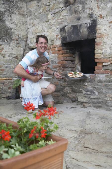 David Lang and daughter Eli makes a pizza in their 400-year-old oven. 