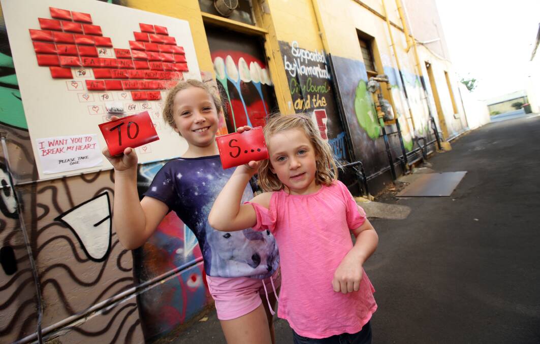 Kiri Hawkes, 8, and Oona Rice, 5, from Warrnambool, discover some clues during the Warrnambool laneways treasure hunt on Saturday. 